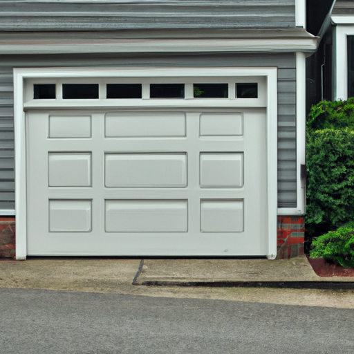 Insulated sectional garage door on a Belmont, MA home showing panels and threshold, daylight exterior.