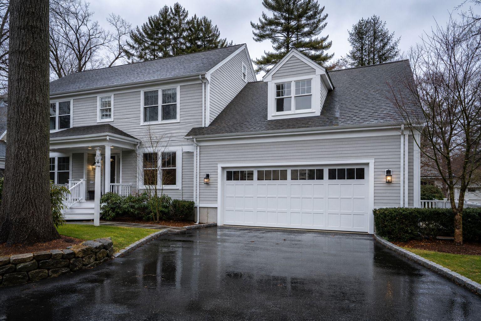 Belmont home exterior with a closed garage door on a wet New England day